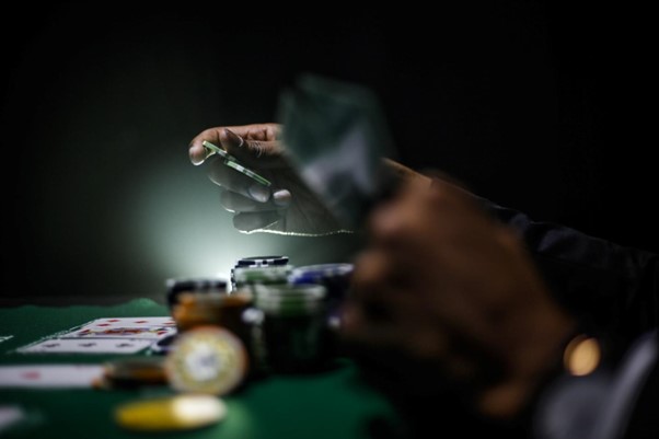 dfdfd888de hands holding casino chips and cards at casino table
