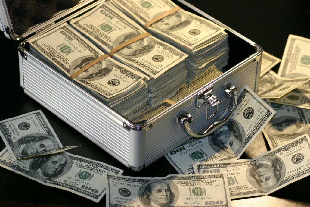 stacks of dollars in and around open aluminum case