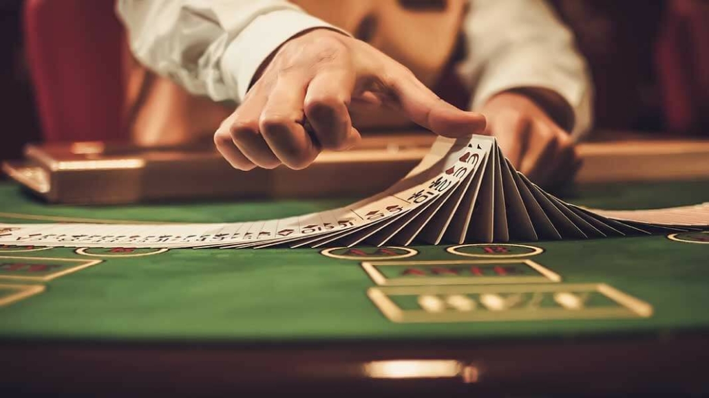 Blackjack dealer shifting deck of cards on casino table