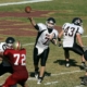 Quarterback throwing football with gridiron players around