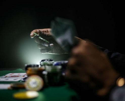 hands holding casino chips and cards at casino table
